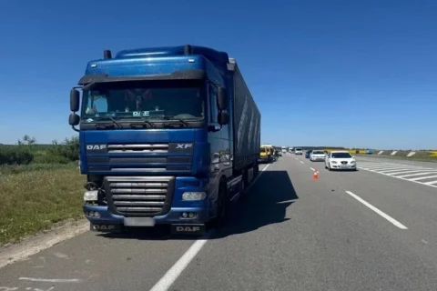 Синій тягач DAF XF на узбіччі траси з конусами та чергою авто