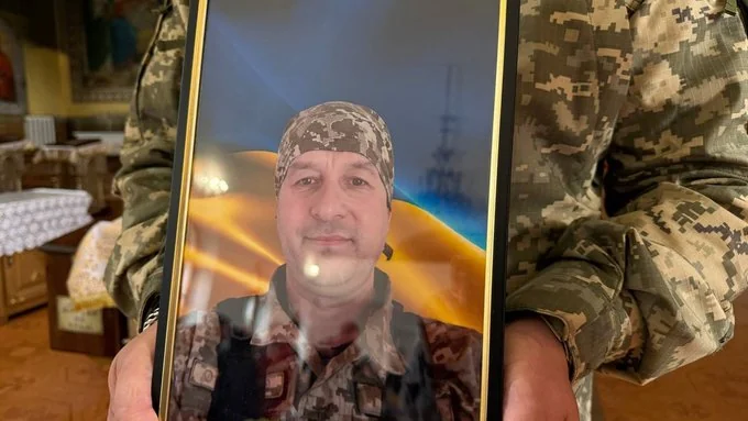 Військові тримають рамку з портретом солдата під час поминальної церемонії