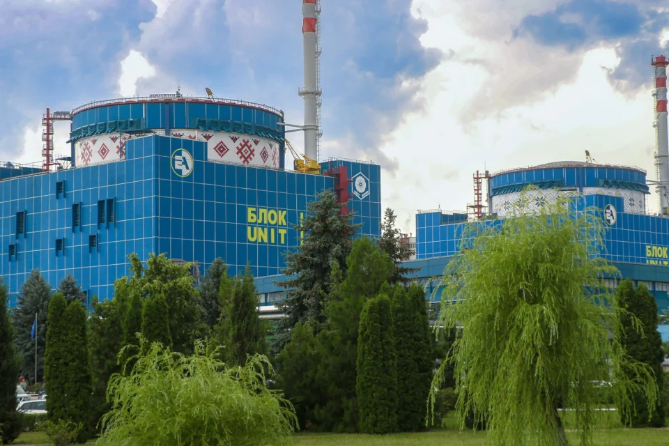 Сині корпуси блоків 1 і 2 Хмельницької АЕС серед дерев