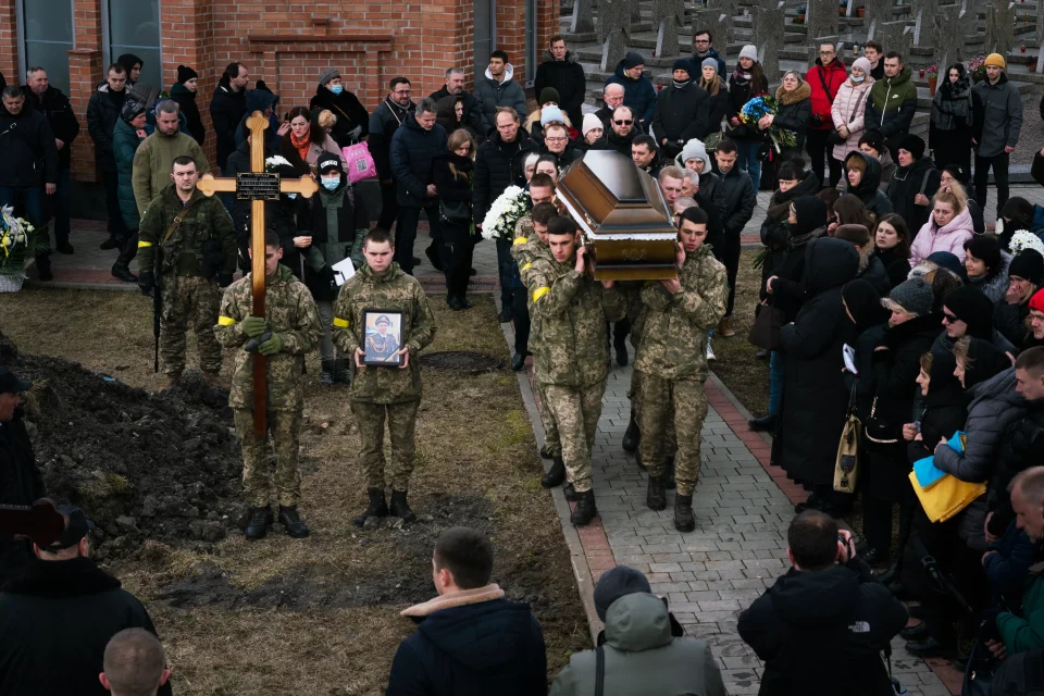 Військові несуть труну з прапором на церемонії поховання